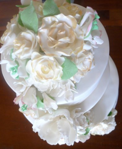 Celebrate Cakes Sugar Flowers - cascade of blossoms including gold tipped sugar roses, sugar orchids and filler blossoms and greenery